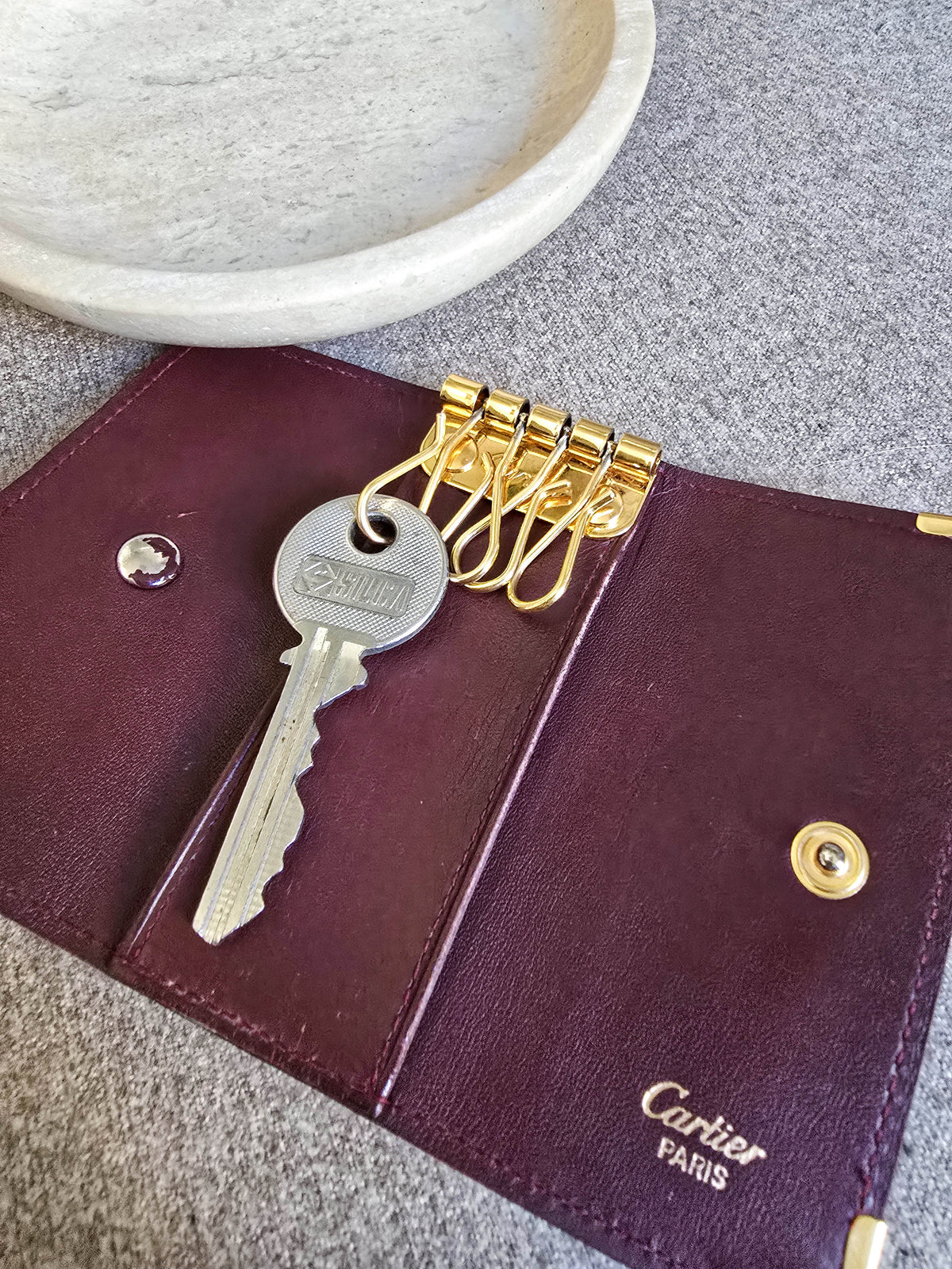 Porté clé multi clé Cartier en cuir lisse bordeaux et bijouterie dorée