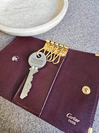Porté clé multi clé Cartier en cuir lisse bordeaux et bijouterie dorée