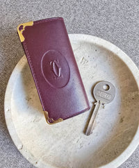 Porté clé multi clé Cartier en cuir lisse bordeaux et bijouterie dorée