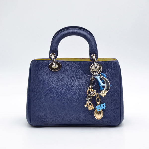 Vue de face Dior Diorissimo Small cuir taurillon grainé bleu, breloques D-I-O-R, occasion authentique — RARR Vintage