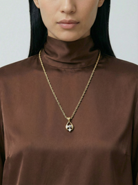 Collier Nina Ricci vintage plaqué or – Pendentif goutte avec strass et logo NR argenté